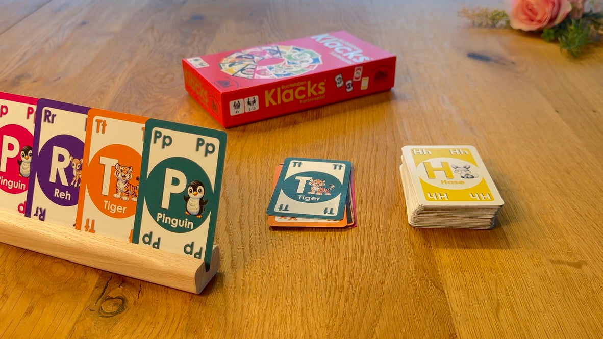 Buchstaben-Klacks-Karten auf einem echten Spieltisch, mit einem Holz-Kartenhalter